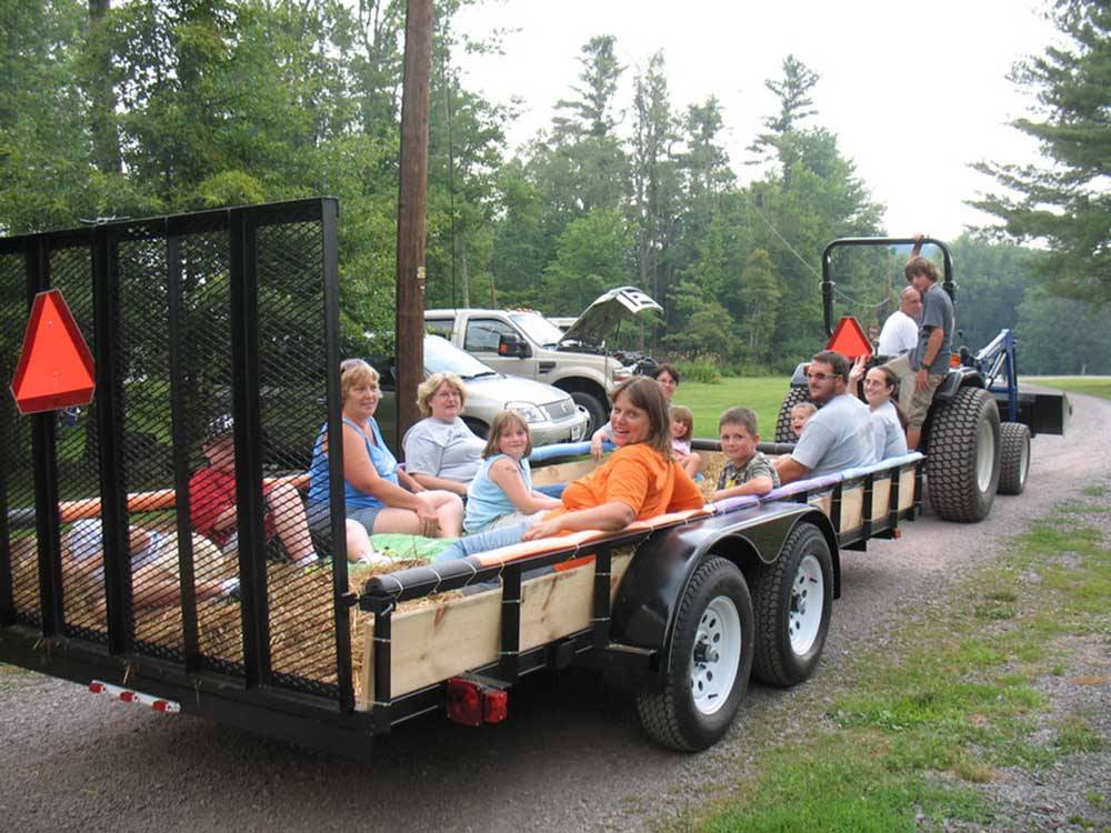 People riding on the back of a trailer at WHISPERING PINES CAMPING ESTATES