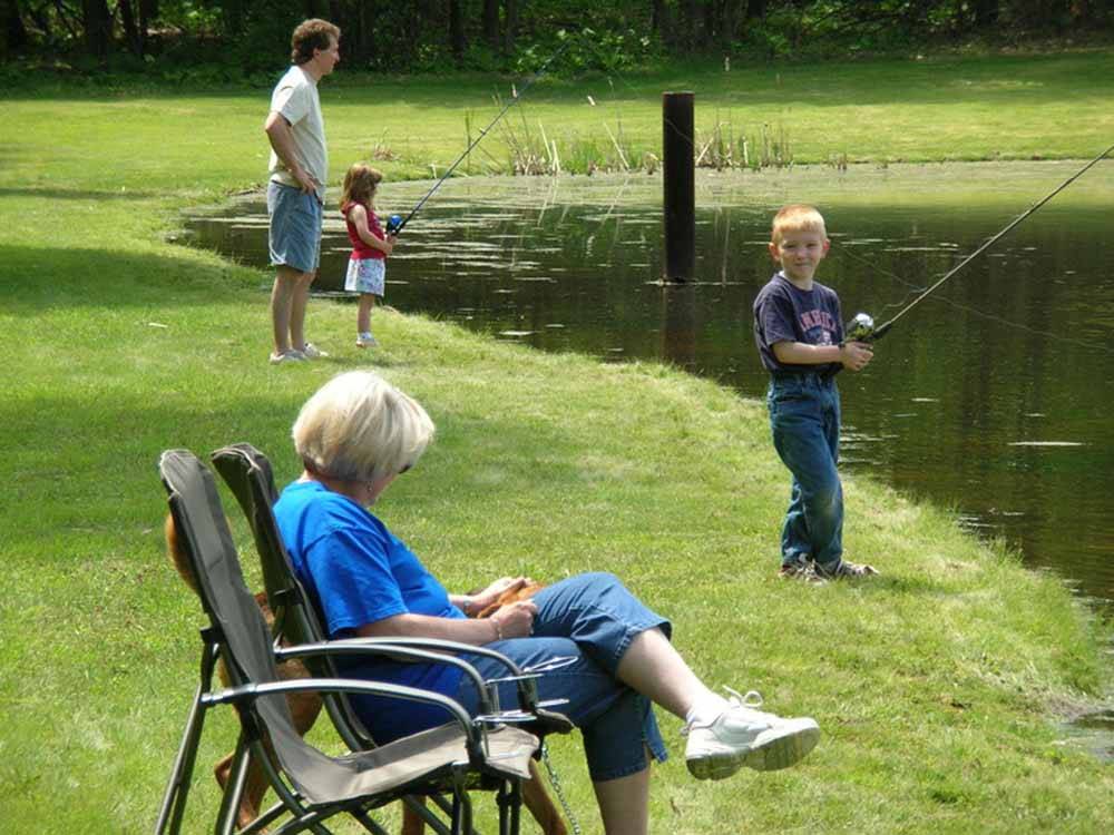 A couple of kids fishing in the pond at WHISPERING PINES CAMPING ESTATES