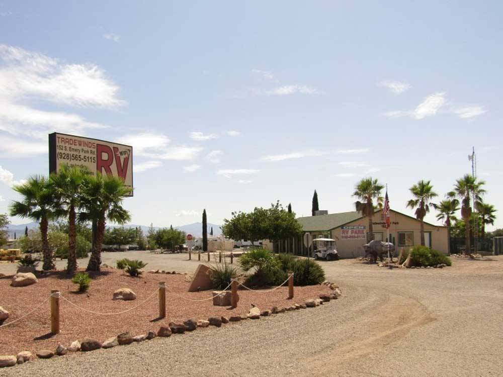 Desert landscaping with park sign and office at TRADEWINDS RV PARK