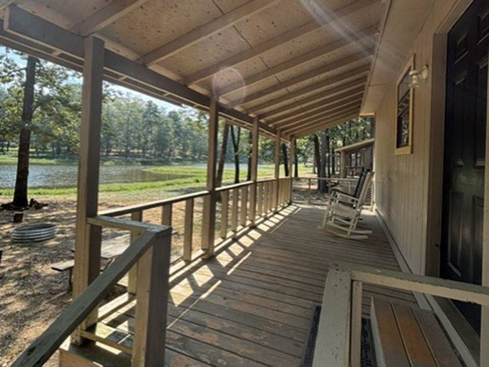 A covered porch with rocking chairs