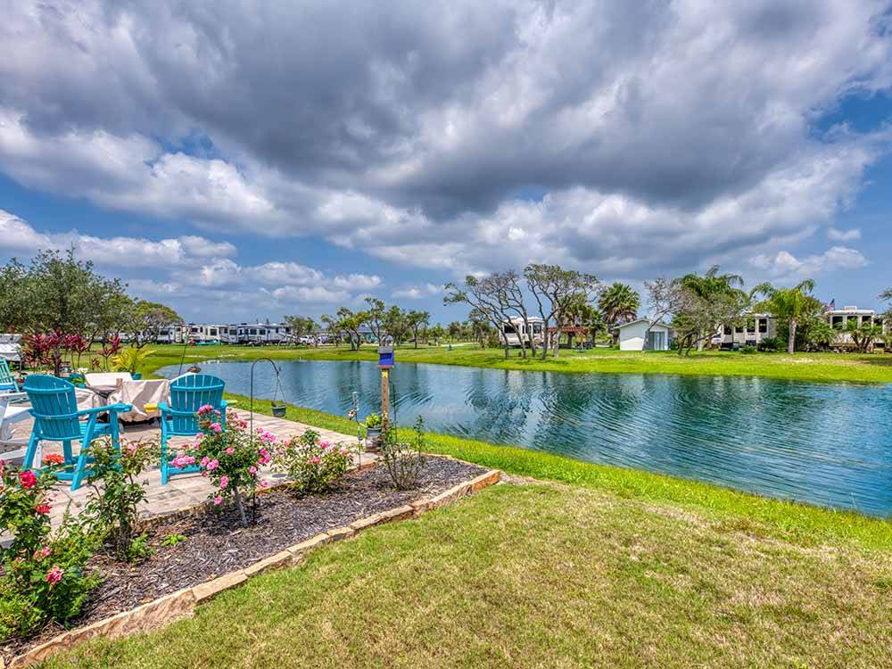 A body of water in a lush grassy resort at SOUTHERN OAKS RV RESORT
