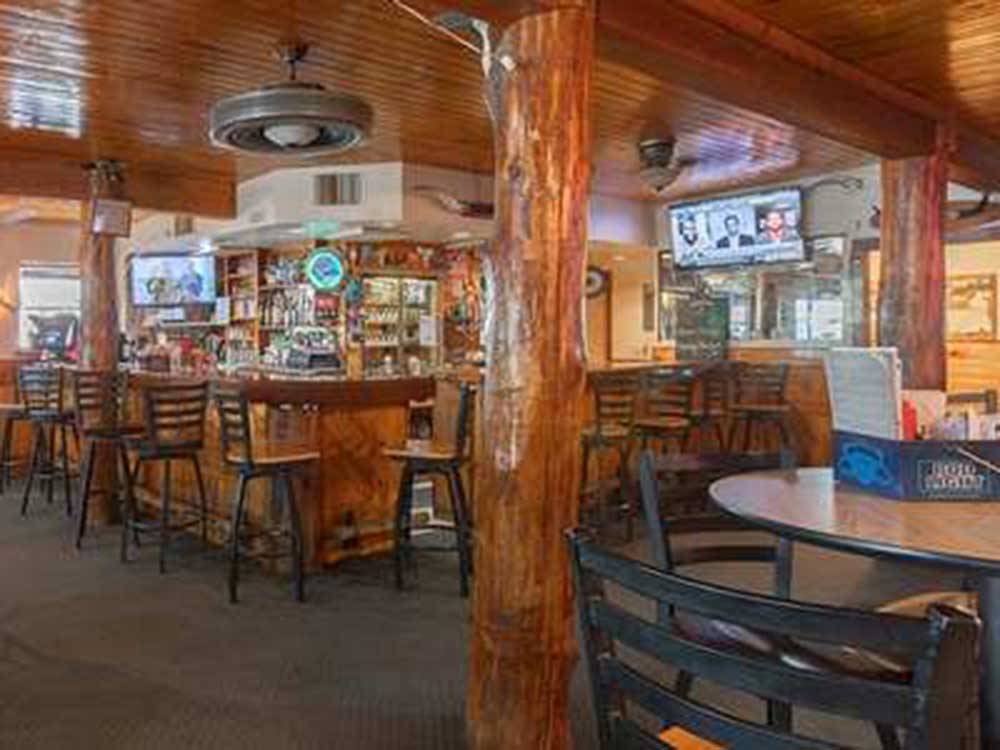 Tables and bar stools inside the saloon at GREYS RIVER COVE RESORT