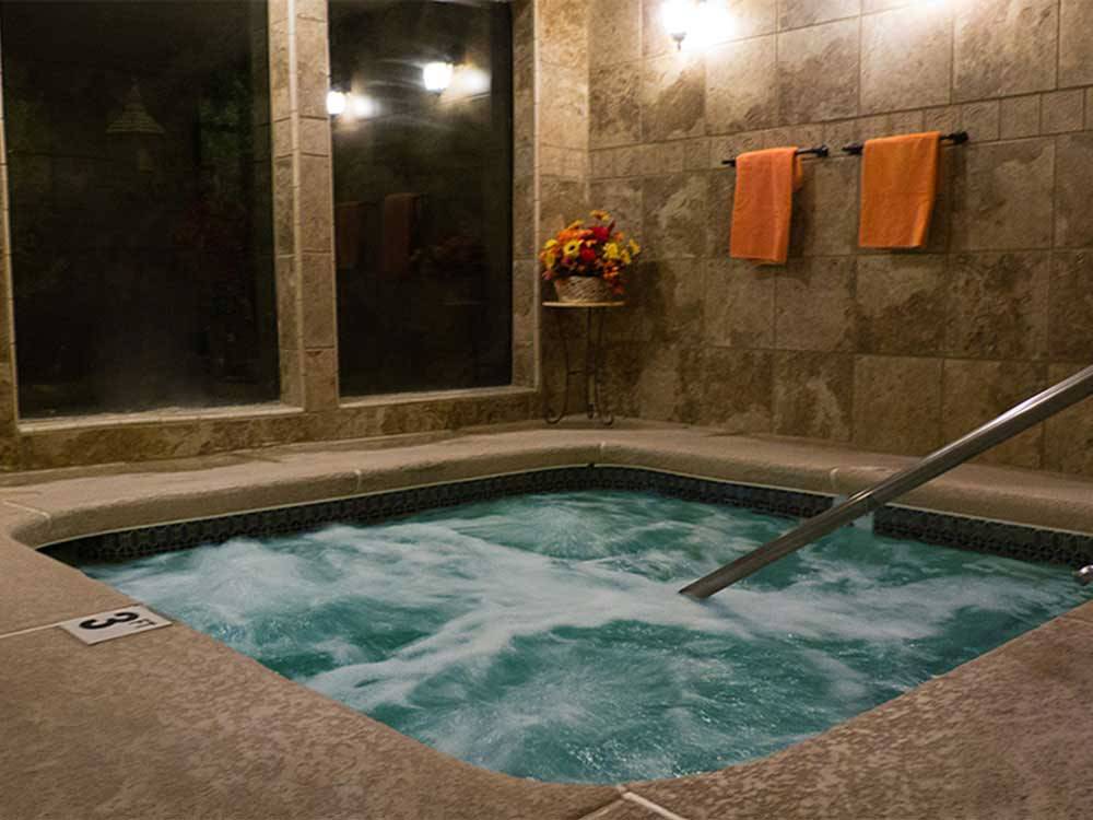 Indoor spa at night with orange towels hanging at PREFERRED RV RESORT