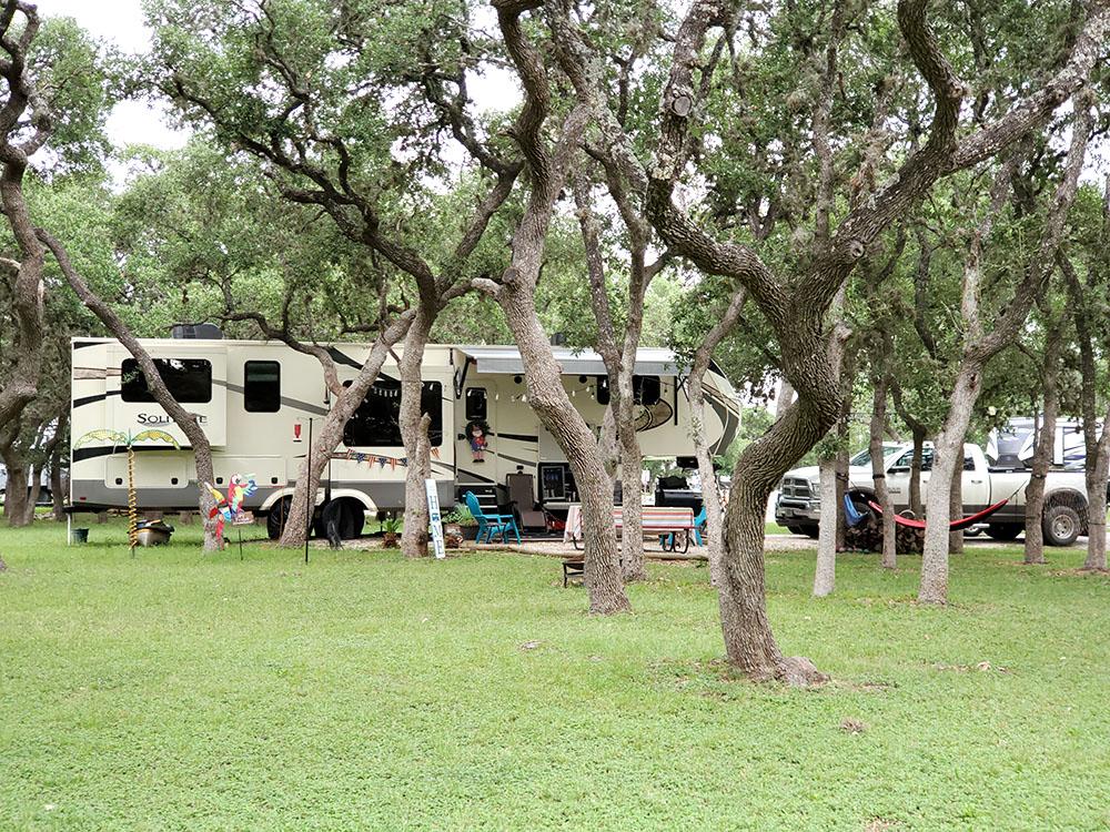 5th wheel parked at a tree lined site at LAKE MEDINA RV RESORT