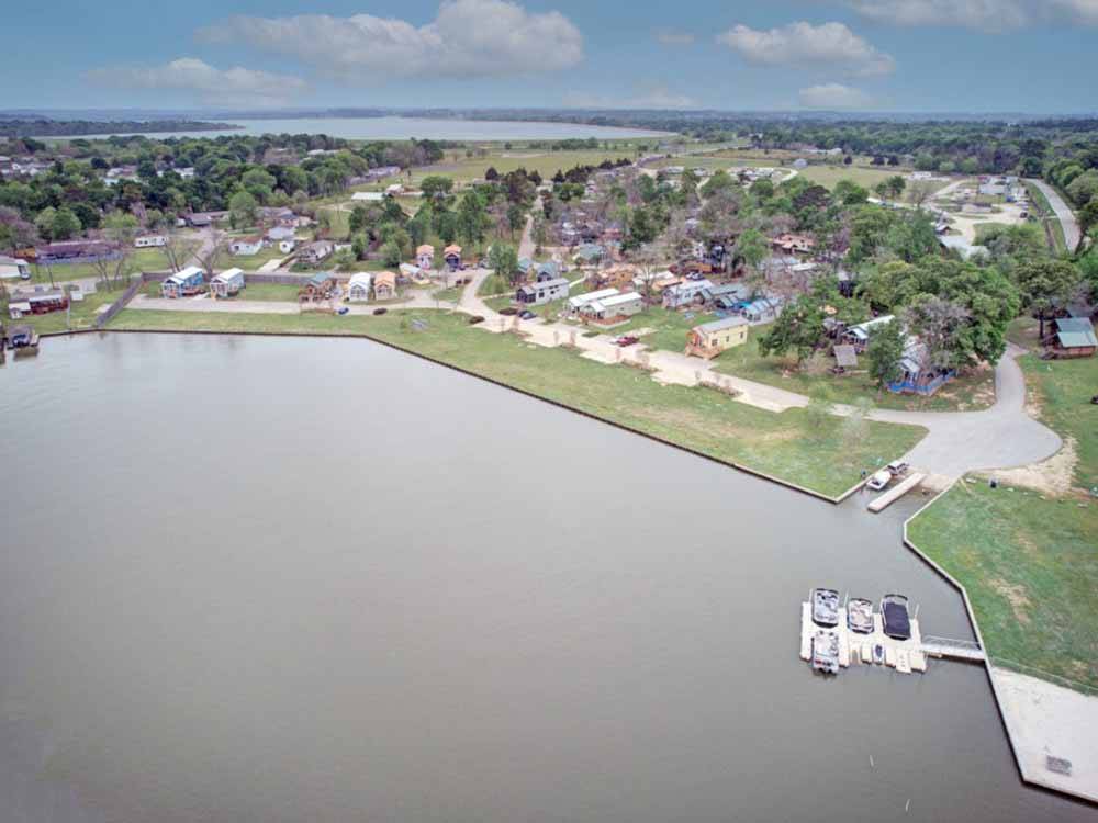 Aerial view over water with resort in background at WATER'S EDGE RV RESORT