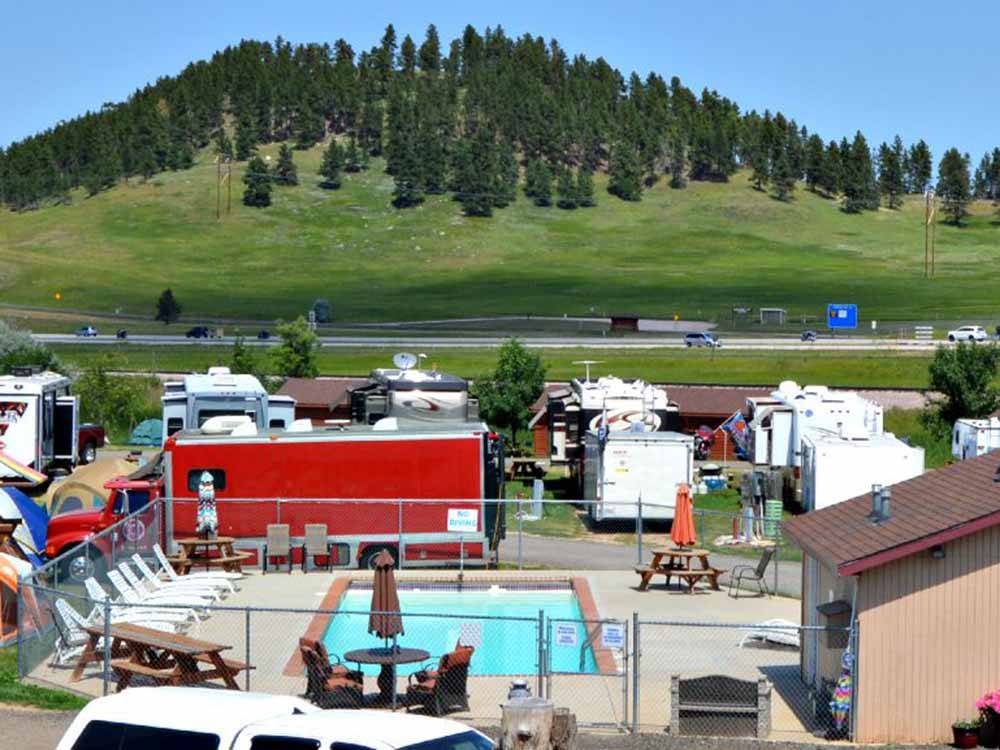 Campground with pool and scenic hill in background at NO NAME CITY LUXURY CABINS & RV PARK