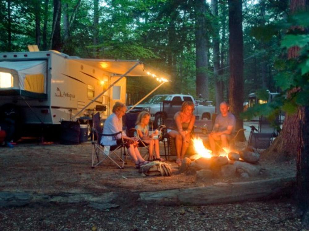 Generational photo of family around a campfire at  Lakeside Pines Campground