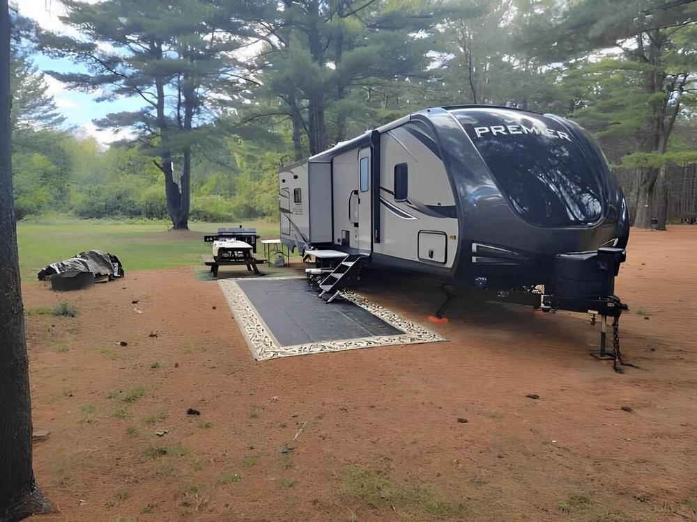 RV at site with picnic table in trees