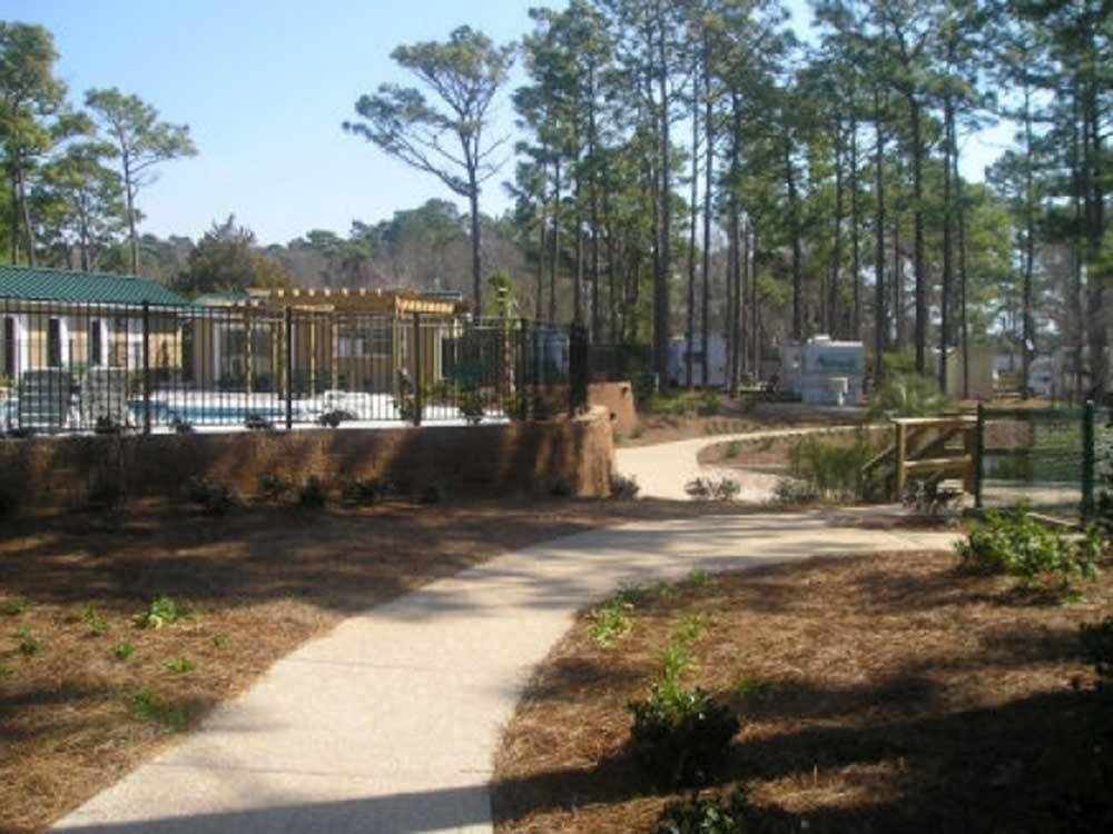 Concrete path to the pool area at WHISPERING PINES CAMPGROUND