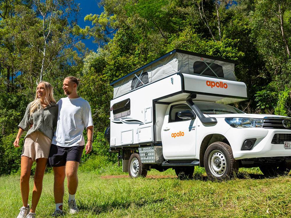 Camper with couple standing nearby