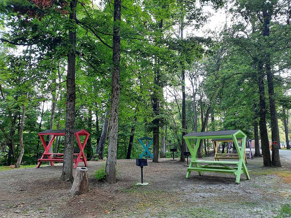 Covered red and green picnic tables at HIDDEN PARADISE CAMPGROUND