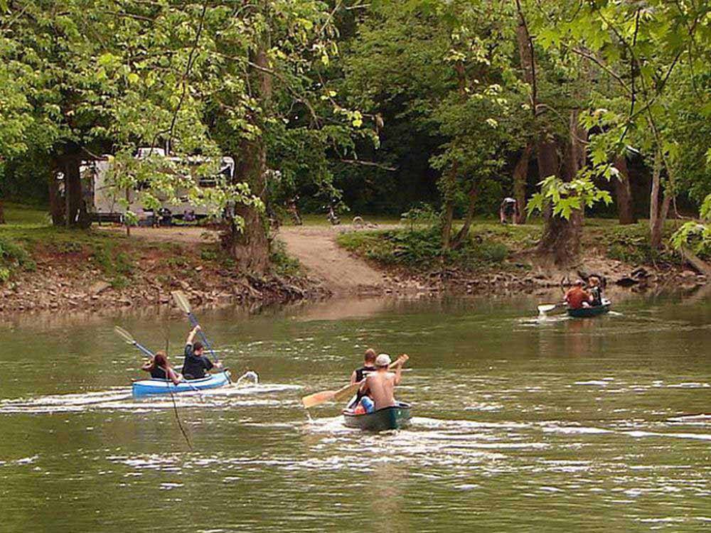 People canoeing and kayaking on the water at HIDDEN PARADISE CAMPGROUND
