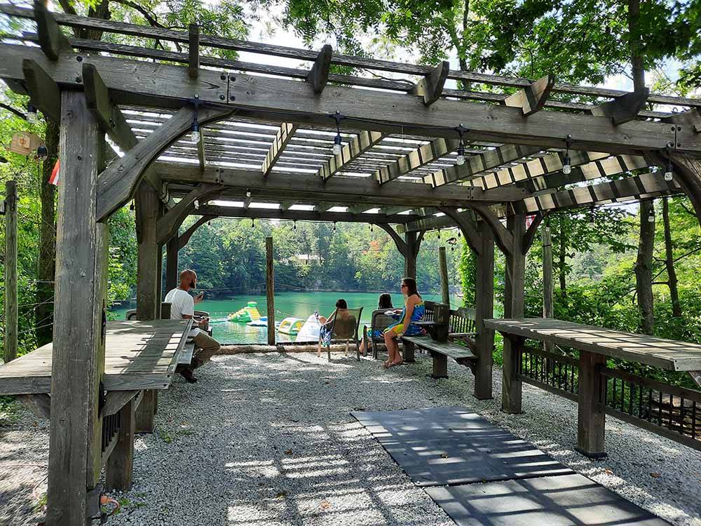 Pergola with people overlooking the water at HIDDEN PARADISE CAMPGROUND
