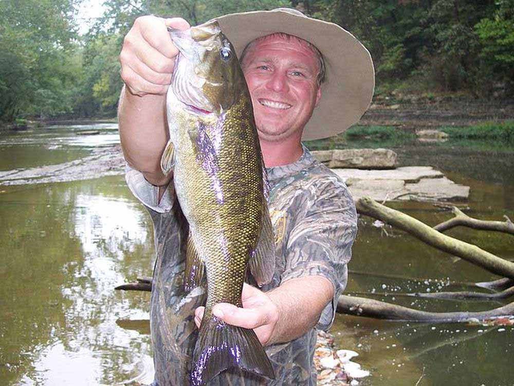 Man holding large fish at HIDDEN PARADISE CAMPGROUND