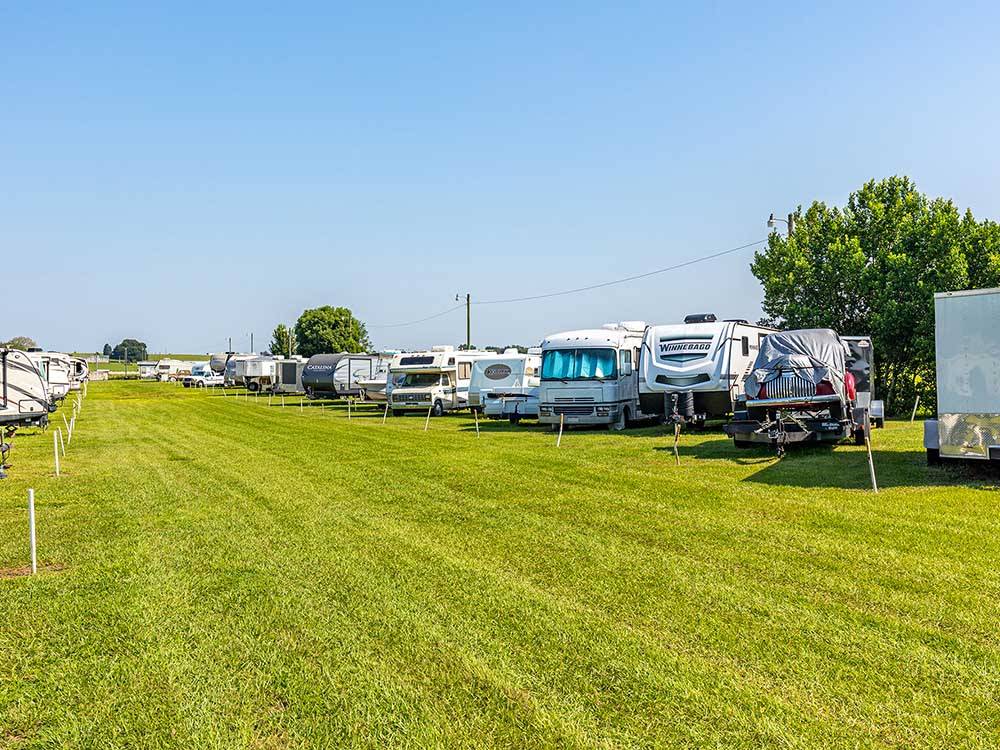 Two rows of motorhomes and trailers parked on grassy sites at SANDBAR RV RESORT
