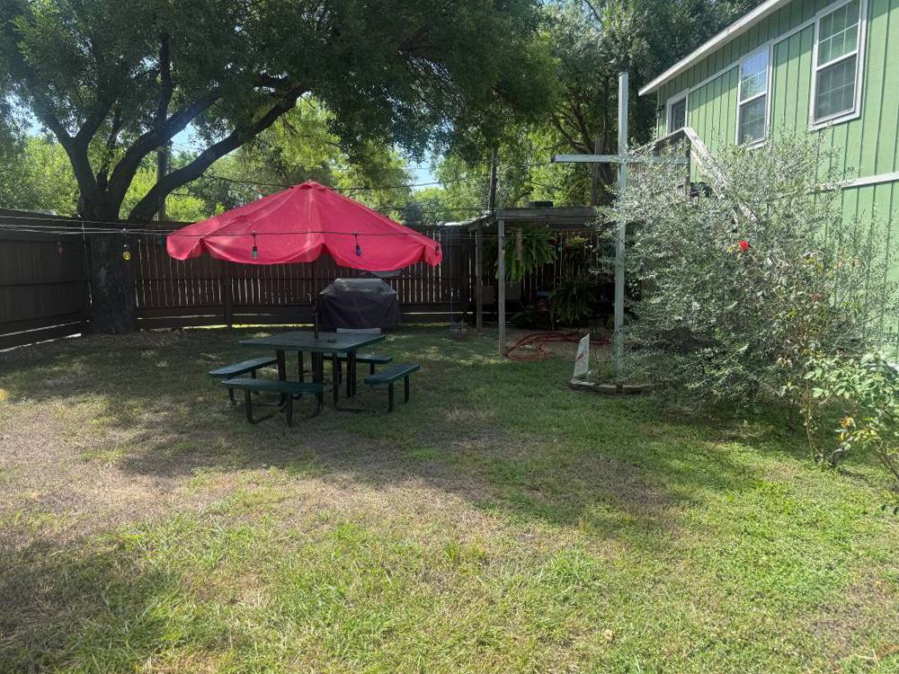 A covered picnic table behind a building