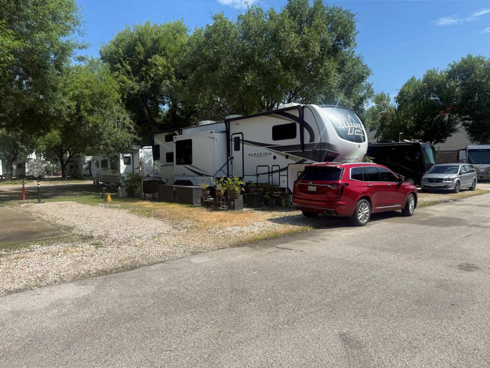 A red car near a fifth wheel trailer