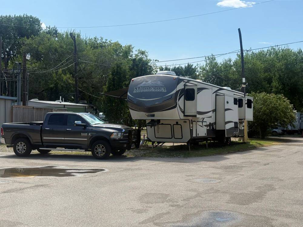 A black pickup near a fifth wheel trailer