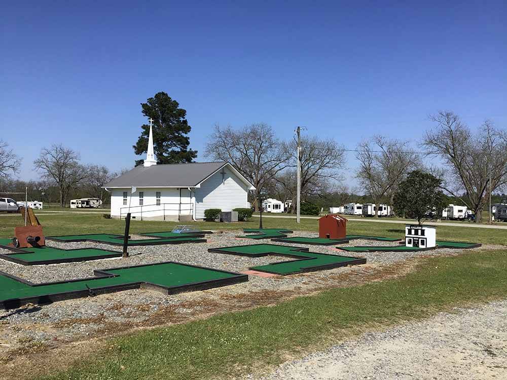 The mini golf course with a church in the background at SOUTHERN TRAILS RV RESORT