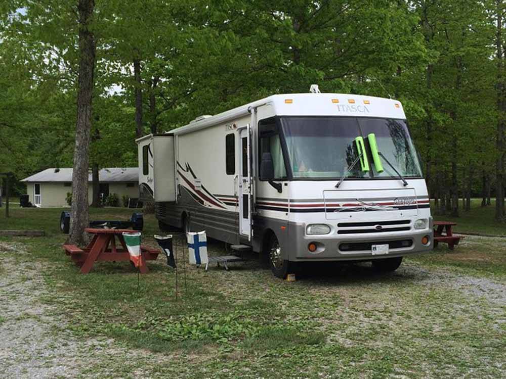 A motorhome in a wooded RV site at BRECKENRIDGE LAKE RESORT