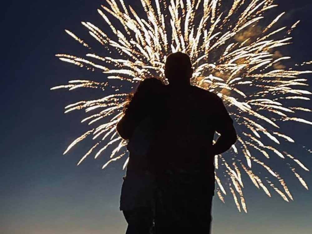 A couple watching a firework display at O'SULLIVAN SPORTSMAN RESORT (CAMPING RESORT)