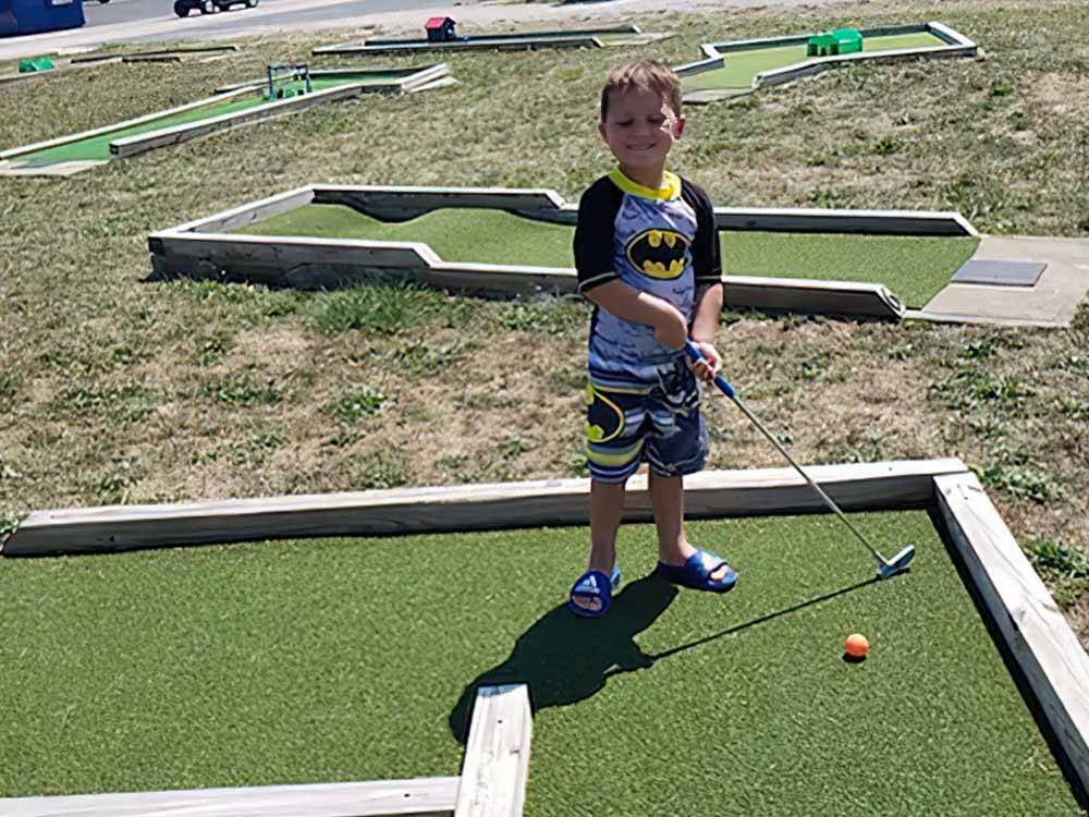 A small boy playing mini golf at THE RESORT AT ERIE LANDING