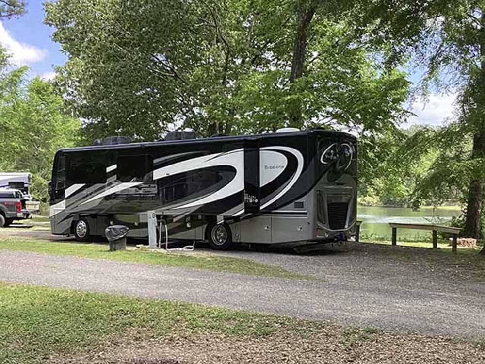 A motorhome on an RV site by the water at WENDY OAKS RV RESORT