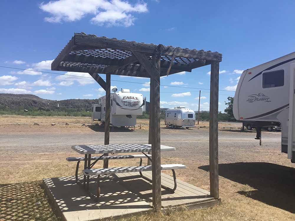 A picnic table under an awning at MACMILLEN RV PARK