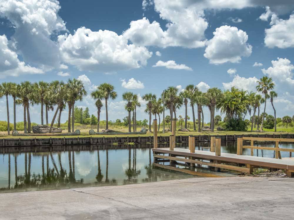 A row of palm trees on the other side of the water at EAST TOHO RV RESORT & MARINA