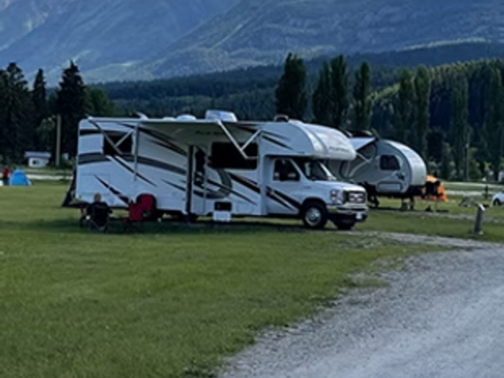 RVs parked in grass sites at Golden Riverfront Campground