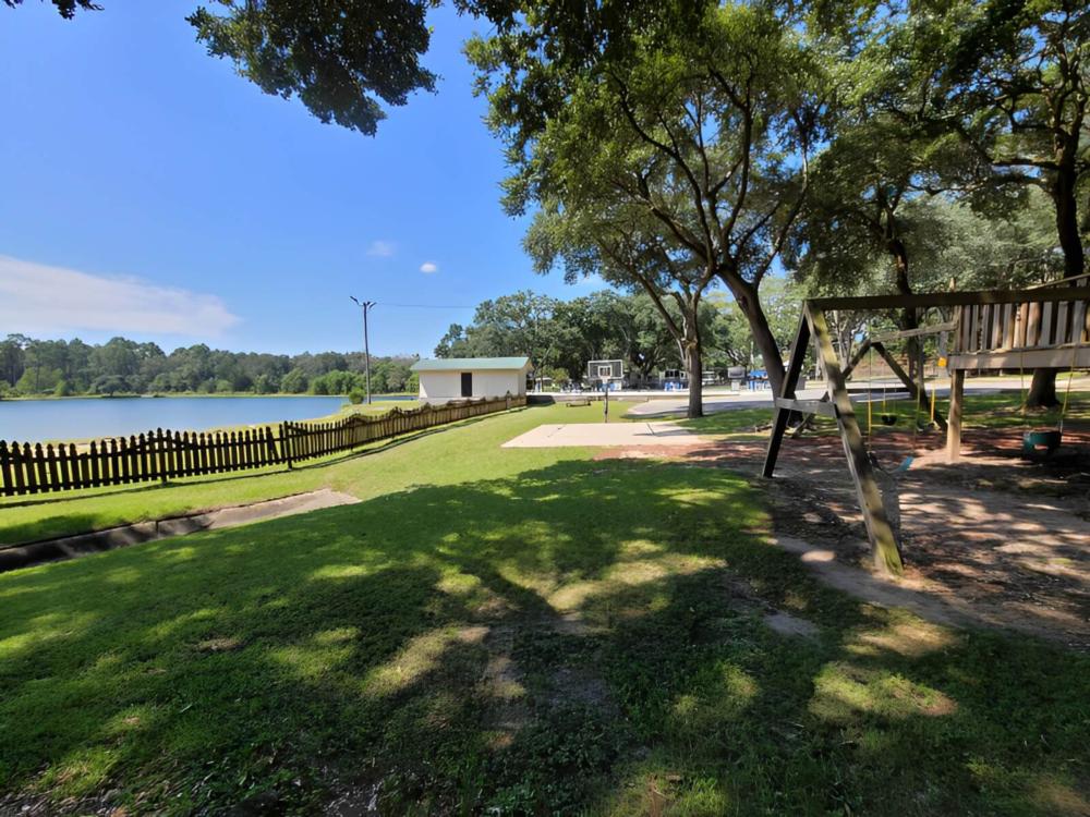 Park with water view at 	Mobile Oaks RV Resort