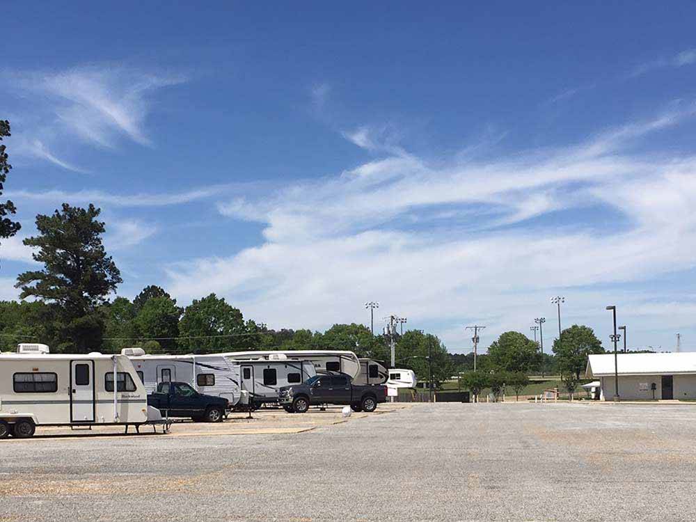 Wide open gravel area with white and tan trailers parked alongside at LINCOLN CIVIC CENTER RV PARK