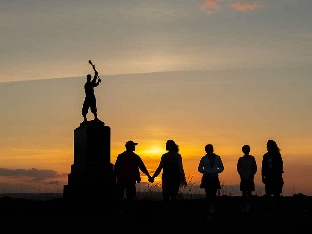 People standing by a statue at sunset at DESTINATION GETTYSBURG