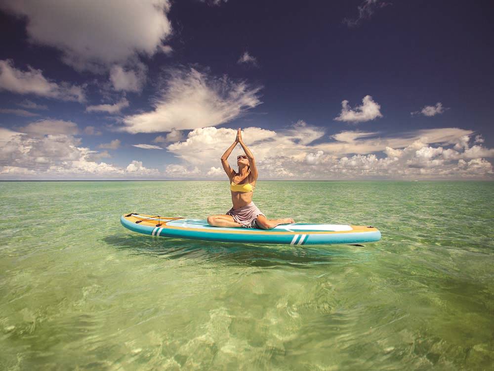 A lady doing exercise on a paddle board in the water at BIG PINE KEY & FLORIDA LOWER KEYS