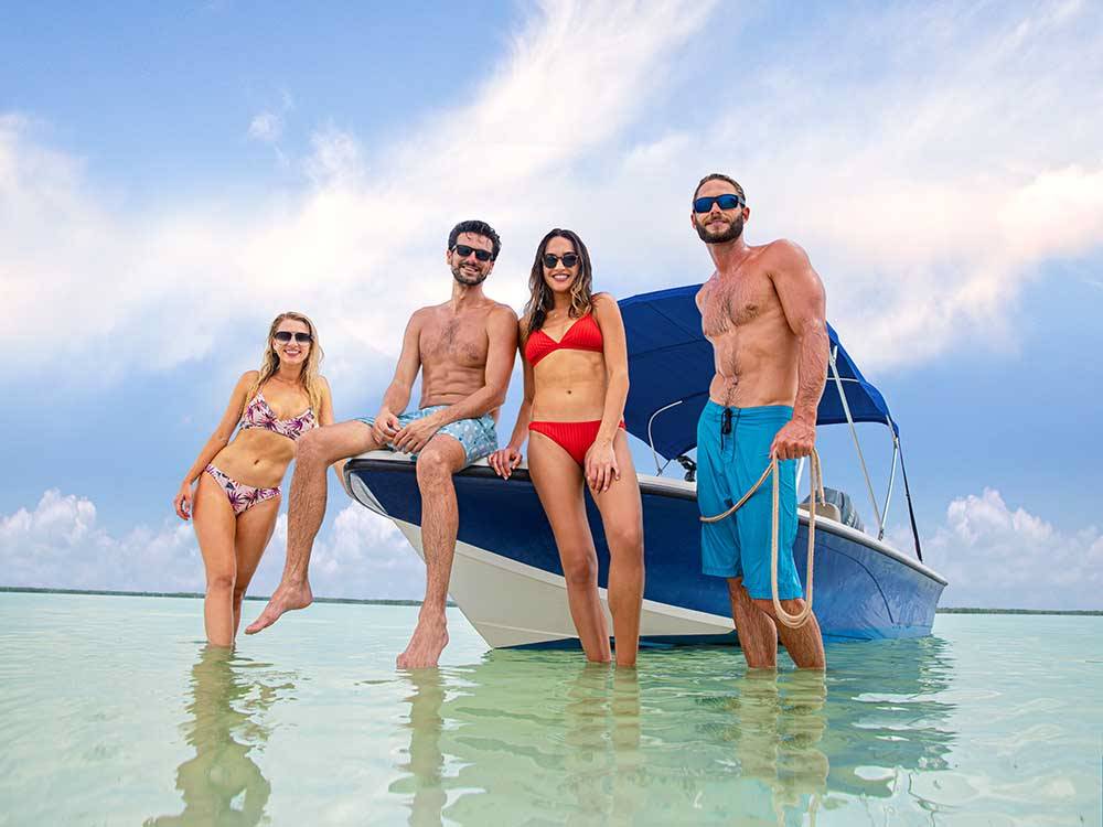 Two couples standing next to a boat in the water nearby at BIG PINE KEY & FLORIDA LOWER KEYS