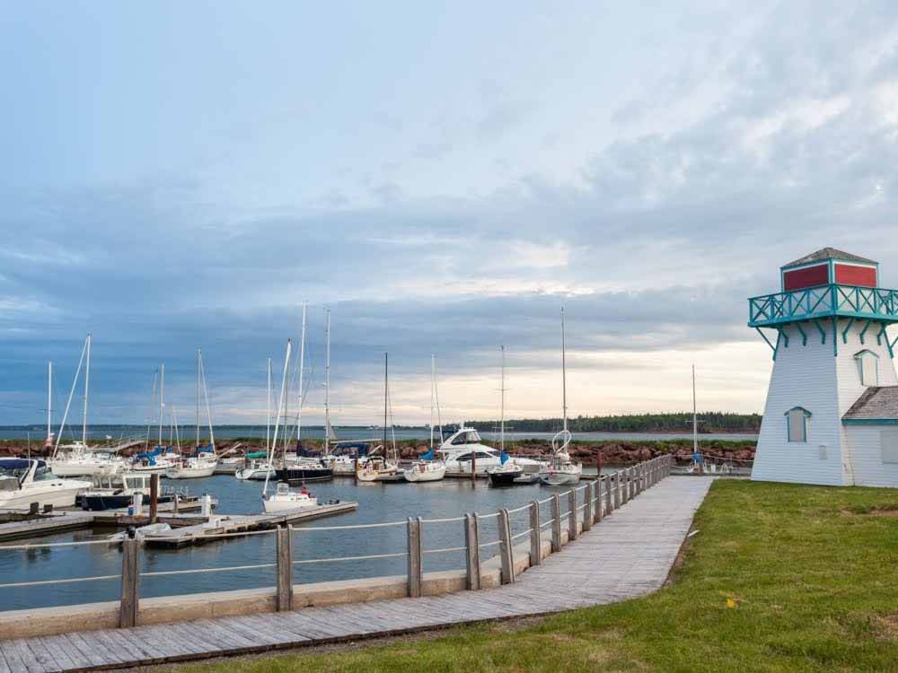 Boats docked by a lighthouse at PEI PROVINCIAL PARKS