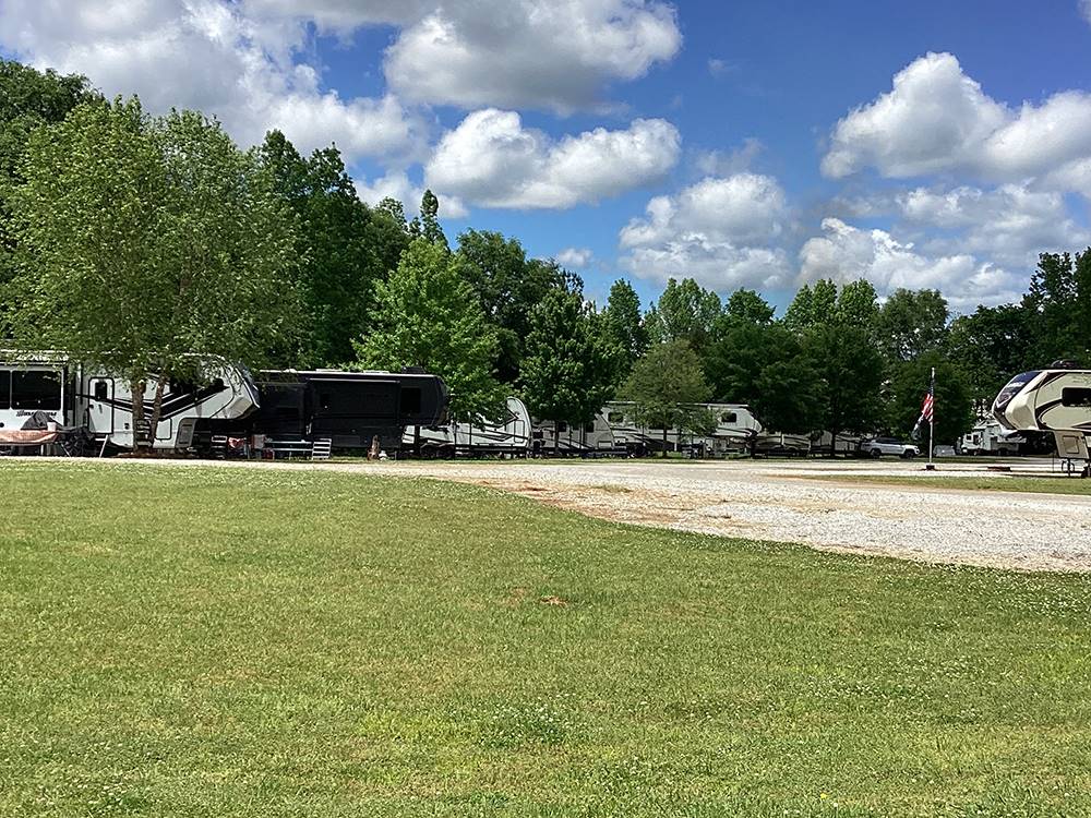 Grassy area next to a gravel RV site at Camping World-Campground of Oxford