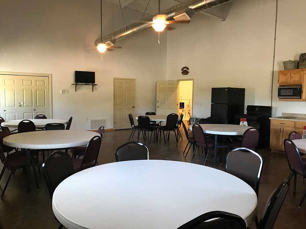 Room with round white tables and chairs at TULSA RV RANCH