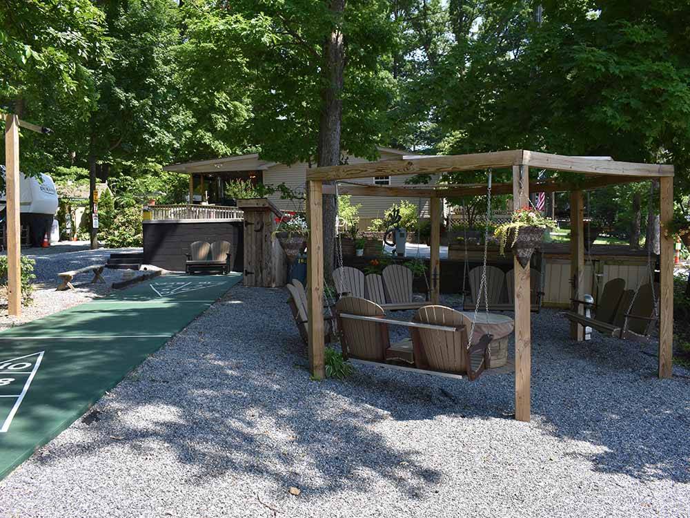 A shuffleboard court and swinging park bench area at OMAS FAMILY CAMPGROUND