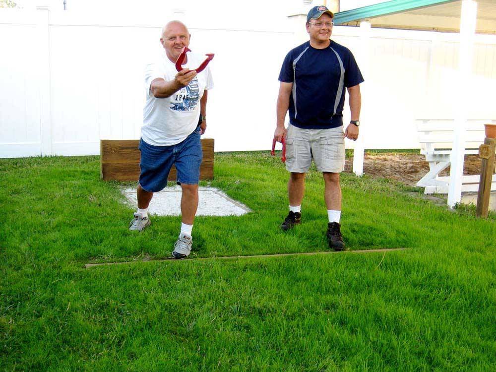 Two men playing horseshoes at WHISPERING PINES