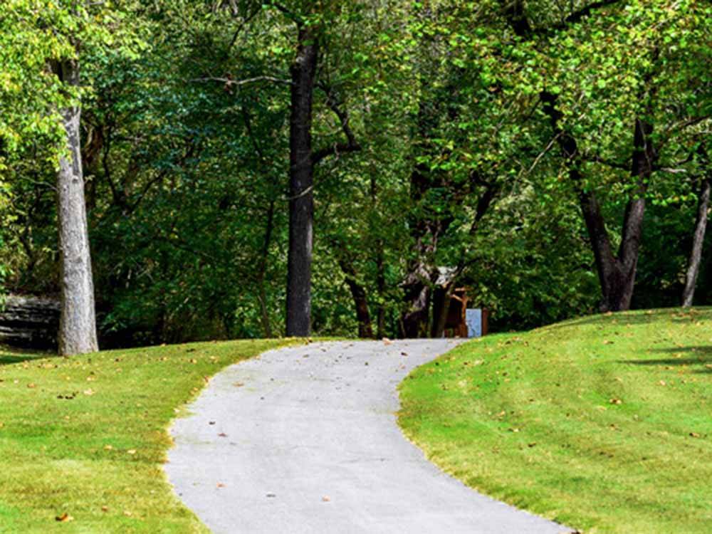 A paved walking path in a grassy area at BLOWING SPRINGS RV PARK