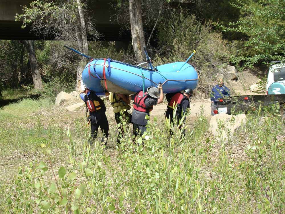 Four people carrying a raft at FRANDY PARK CAMPGROUND