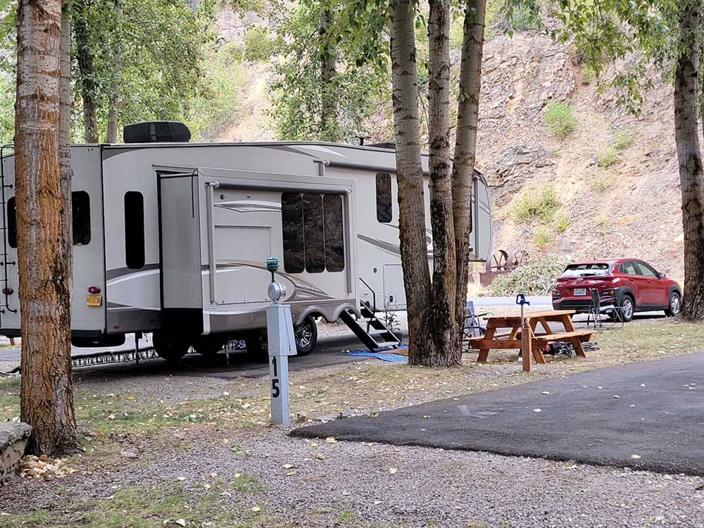 A fifth wheel parked next to a picnic bench at CRYSTAL GOLD MINE & RV PARK