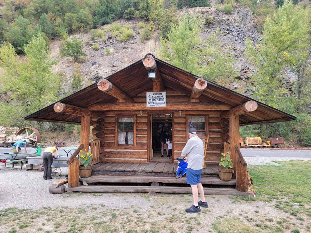 A man standing in front of the Goldmine Museum at CRYSTAL GOLD MINE & RV PARK