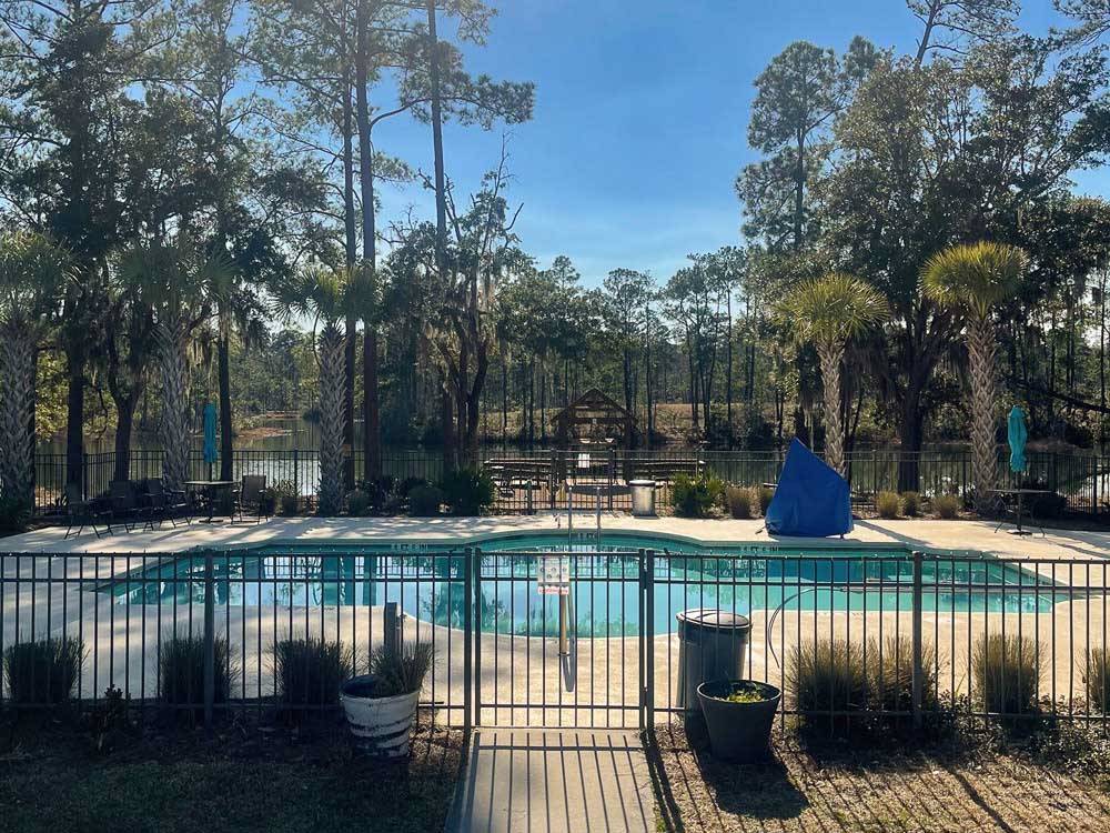 Pool surrounded by waist-high wrought-iron fence at LAKE JASPER RV VILLAGE