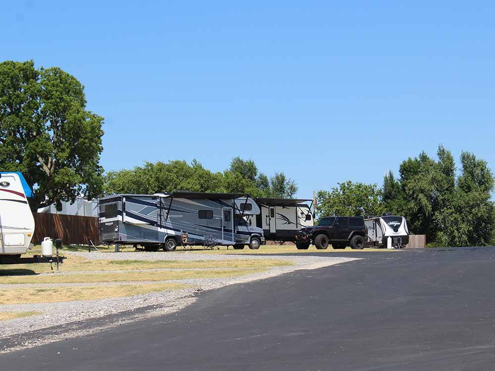 A paved road in front of some RV sites at PECAN GROVE RV RESORT