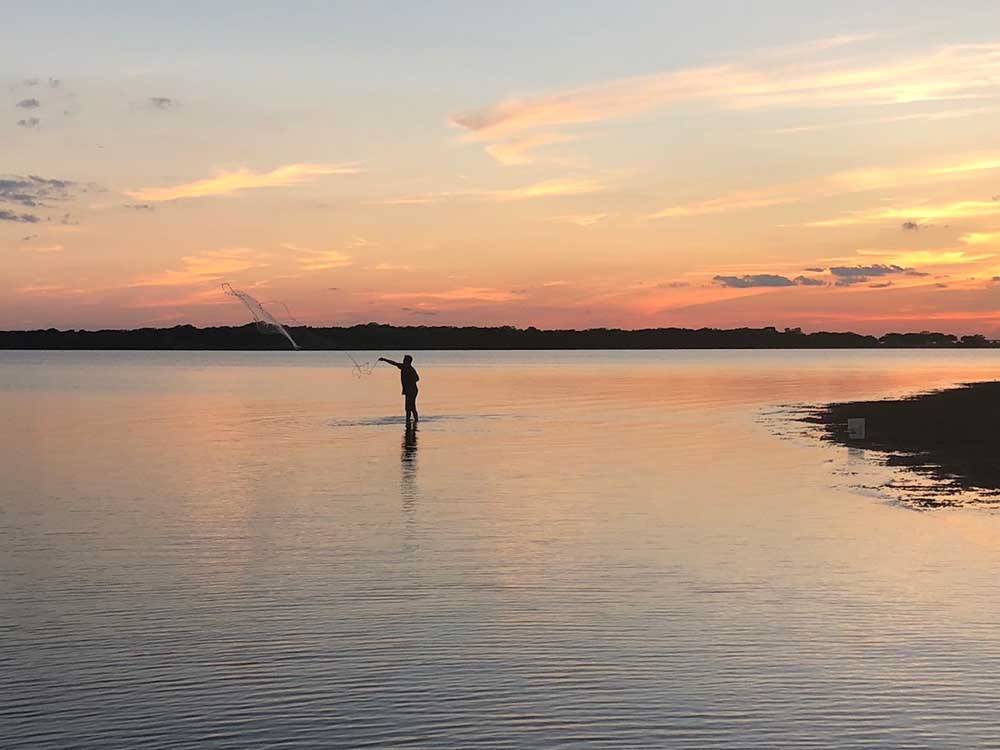 A man fly fishing at sunset at BRACKENRIDGE RECREATION COMPLEX-TEXANA PARK & CAMPGROUND