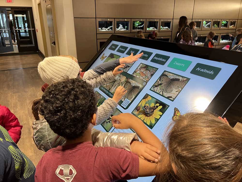 Children looking at a monitor showing insects at BRACKENRIDGE RECREATION COMPLEX-TEXANA PARK & CAMPGROUND