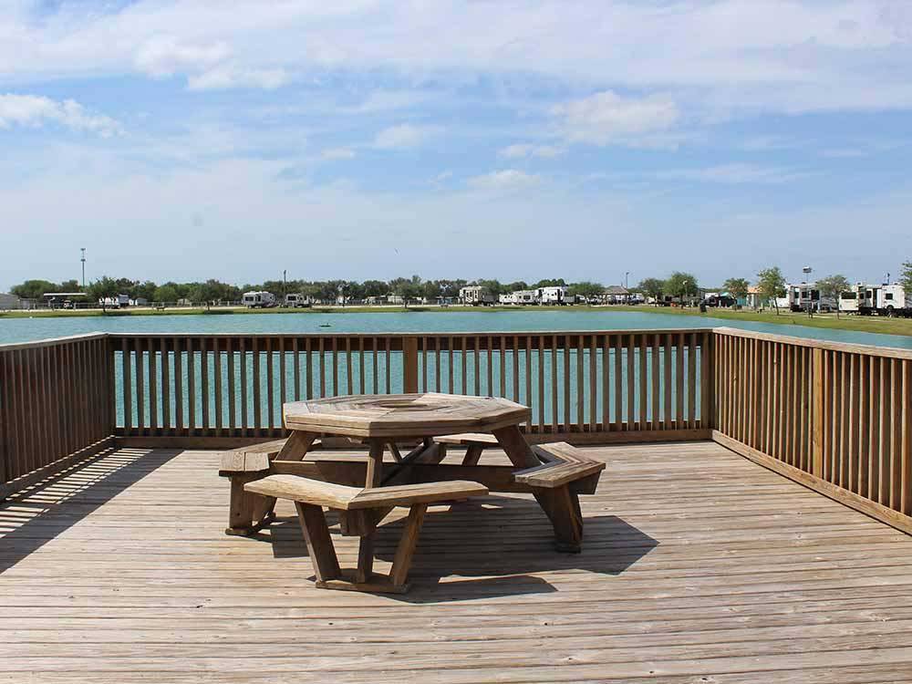 A table and seats on the bridge in the lake at TEXAS LAKESIDE RV RESORT