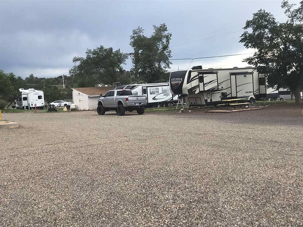 Gravel campsites with vehicles parked nearby at GRAND CANYON VIEW RV